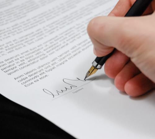 Close up of someone signing document